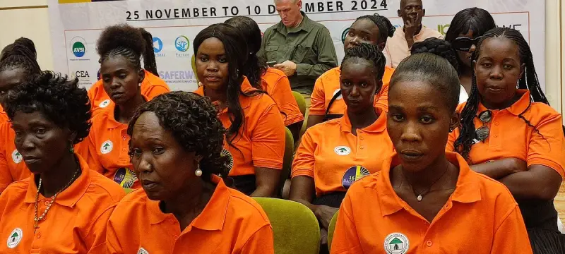 Women in orange event shirts seated in rows at the 16 Days of Activism event