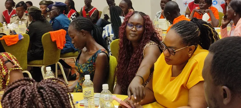 Women in discussion around a table during a Women Frontline Doctors community session
