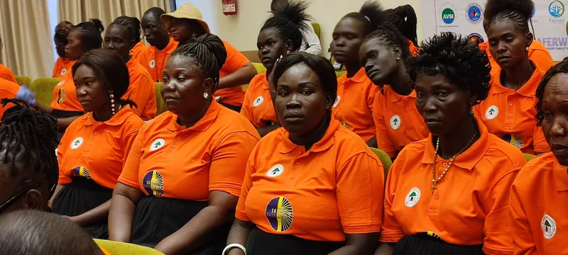 Women participants in orange shirts at a community awareness event